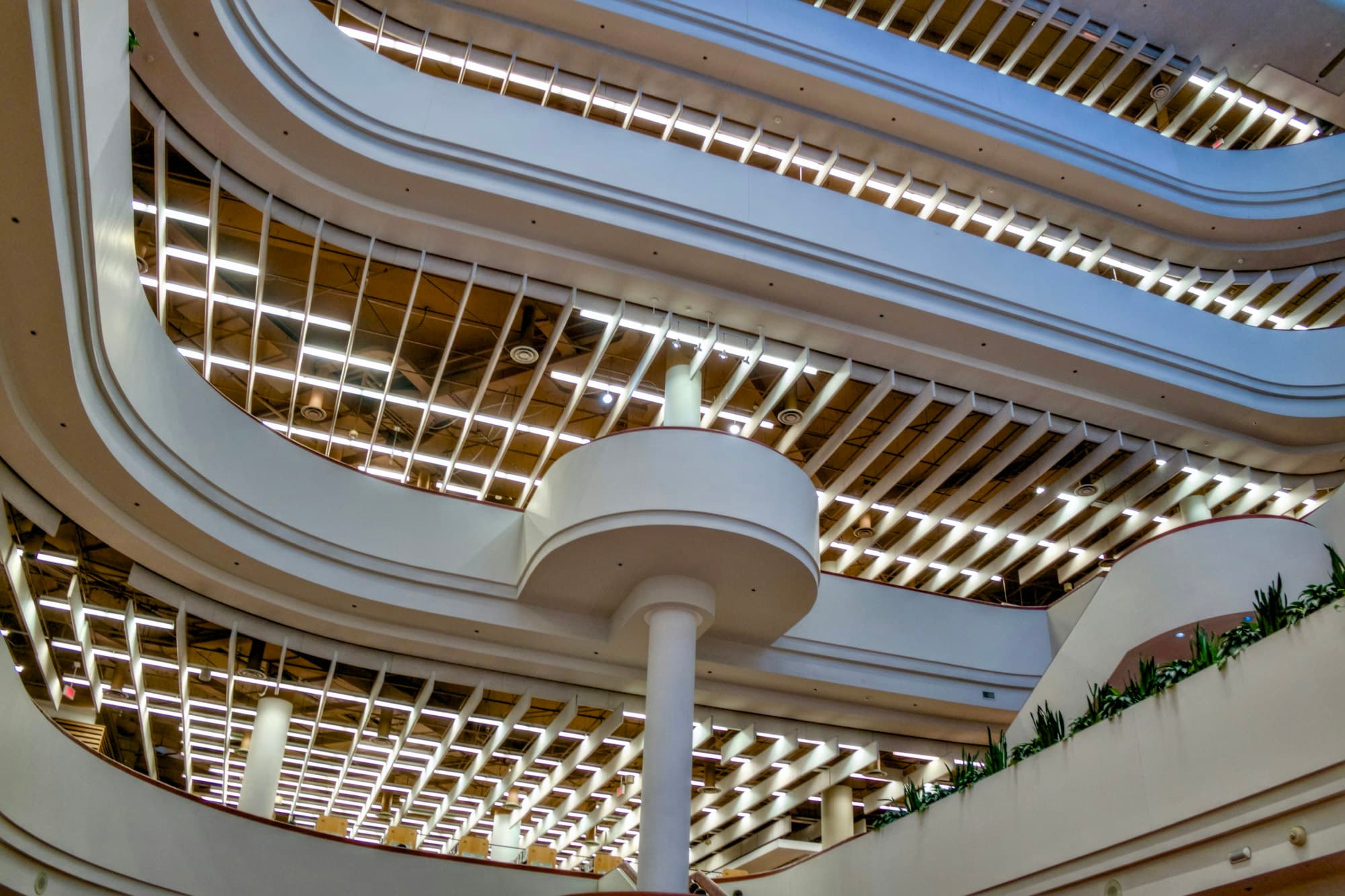 Lobi gedung kantor multi-lantai dengan tangga modern