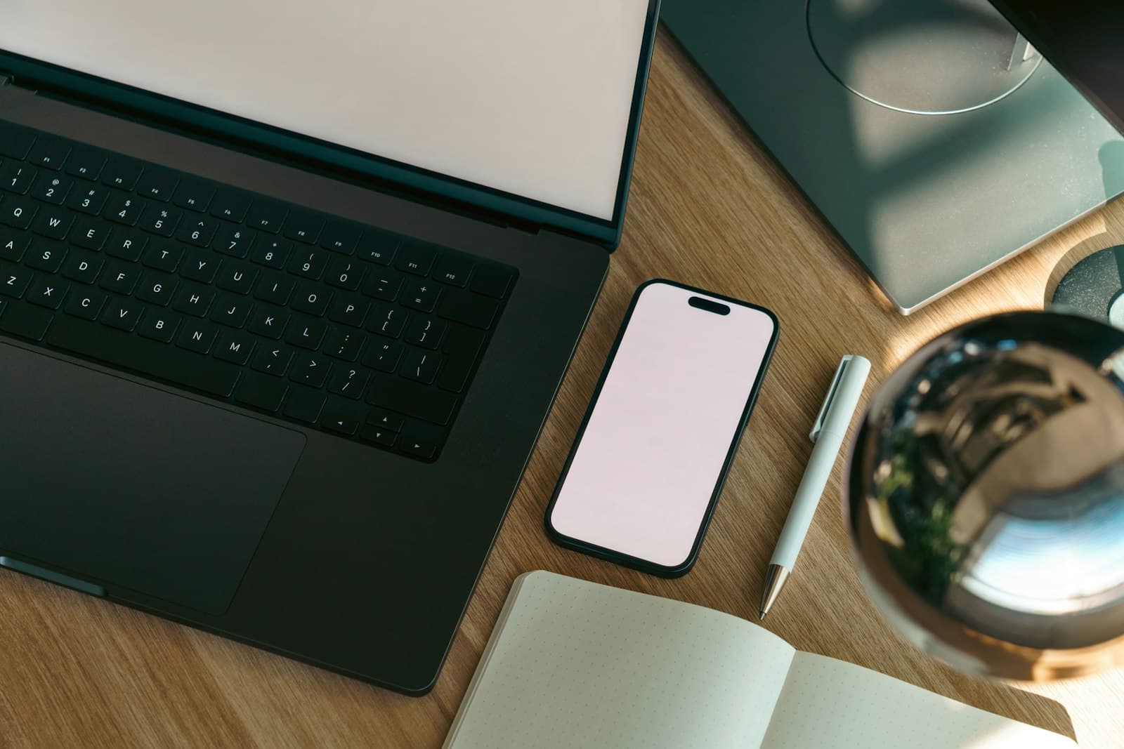 A planning workspace with laptop, notebook, and phone